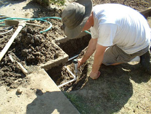 one of our Richmond TX sprinkler repair experts is fixing a brokem head